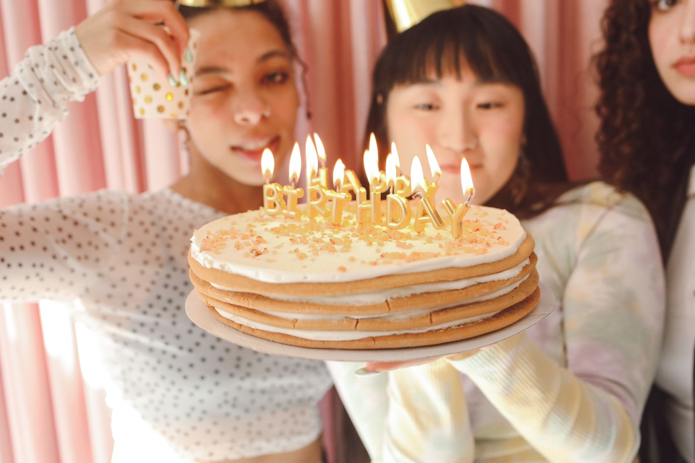 Friends celebrating with a birthday cake and lit candles